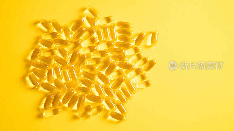 鱼肝油欧米茄3凝胶胶囊分离在黄色背景。鱼油中的Omega - 3胶囊